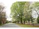A street view features a tree-lined road with blossoming trees and a train track at 505 E Graham St, Mebane, NC 27302