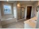 Well-lit bathroom with a soaking tub, glass-enclosed shower, and a spacious vanity area at 540 Eversden Dr, Zebulon, NC 27597
