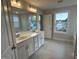 Elegant bathroom with double sink vanity, large mirror, modern fixtures, and tile flooring at 540 Eversden Dr, Zebulon, NC 27597