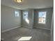 Bedroom with plush carpeting, neutral walls, and three windows, allowing ample natural light at 540 Eversden Dr, Zebulon, NC 27597