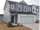 Charming two-story home with a two-car garage and a modern design, featuring gray siding and a welcoming entrance at 540 Eversden Dr, Zebulon, NC 27597