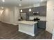 Open-concept kitchen design with a gray kitchen island, stainless steel appliances, and modern lighting fixtures at 540 Eversden Dr, Zebulon, NC 27597