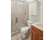 Bathroom featuring tiled shower, toilet, vanity with sink and white storage cabinet at 5507 Vista View Ct, Raleigh, NC 27612