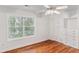 Bedroom featuring hardwood floors, white trim, a large window, and white storage cabinets at 5507 Vista View Ct, Raleigh, NC 27612