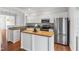 Bright kitchen features stainless appliances, granite countertops, and a butcher block island with white cabinets at 5507 Vista View Ct, Raleigh, NC 27612