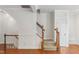 The staircase features hardwood trim with carpeted steps and a nearby door to the outside at 5507 Vista View Ct, Raleigh, NC 27612