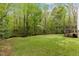 Large grassy backyard with mature trees and deck, perfect for outdoor living at 5541 Old Still Rd, Wake Forest, NC 27587