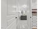 Hallway leading to a bathroom featuring a gray vanity and decorative mirrors at 5541 Old Still Rd, Wake Forest, NC 27587