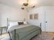 Bright bedroom with a metal frame bed, modern lighting fixture, and neutral colors creating a soothing space at 612 E Ellerbee St, Durham, NC 27704