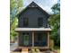 Charming two-story home featuring a quaint front porch, dark gray siding and wood post supports at 612 E Ellerbee St, Durham, NC 27704