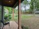 An inviting front porch with wood floors, two modern chairs, and wood support posts at 612 E Ellerbee St, Durham, NC 27704