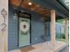A well-lit front porch featuring a decorative wood ceiling, seating and a green front door at 612 E Ellerbee St, Durham, NC 27704