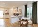 Eat-in kitchen featuring a breakfast bar, modern appliances, white cabinetry, and hardwood flooring at 612 E Ellerbee St, Durham, NC 27704