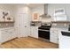 Well-lit kitchen area with white cabinets, stainless steel appliances, stylish decor, and hardwood flooring at 612 E Ellerbee St, Durham, NC 27704