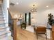 Beautiful open living space features hardwood floors, a modern chandelier, and a glimpse of the kitchen and staircase at 612 E Ellerbee St, Durham, NC 27704