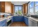 Stylish condo kitchen with stainless steel appliances, blue cabinets, and granite countertops at 618 N Boylan Ave # 304, Raleigh, NC 27603