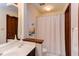 Well-lit bathroom with a modern sink, traditional cabinets, and a shower with white curtain at 635 Kensington Dr, Chapel Hill, NC 27514