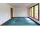 Bedroom featuring green carpet, natural light from large windows, and wooden trim at 635 Kensington Dr, Chapel Hill, NC 27514