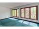 Bedroom featuring green carpet, natural light from four windows, and wooden trim at 635 Kensington Dr, Chapel Hill, NC 27514
