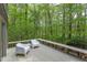 View of deck overlooking lush backyard with two chairs and small table at 635 Kensington Dr, Chapel Hill, NC 27514