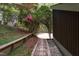 Picturesque side yard with a brick path, lush greenery, and a wooden retaining wall at 635 Kensington Dr, Chapel Hill, NC 27514