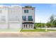 Charming three-story townhome with a street view and manicured lawn and a blue awning at the entry at 670 Bandon Aly, Cary, NC 27513