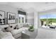 Living room features modern chess decor, a white sectional sofa, and a large window with a bright balcony at 670 Bandon Aly, Cary, NC 27513