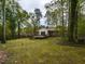 Backyard view of the home, showcasing the deck and wooded surroundings at 6813 W Lake Anne Dr, Raleigh, NC 27612