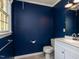 Bathroom features a modern vanity, toilet, and dark blue accent wall at 6813 W Lake Anne Dr, Raleigh, NC 27612
