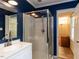 Contemporary bathroom featuring a shower stall, vanity, and bright lighting at 6813 W Lake Anne Dr, Raleigh, NC 27612