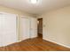 Bedroom features hardwood flooring, neutral paint, and large closet at 6813 W Lake Anne Dr, Raleigh, NC 27612