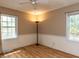 Bedroom with wood floors, two windows, and neutral paint at 6813 W Lake Anne Dr, Raleigh, NC 27612