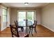 Bright dining room with hardwood floors, a large table, and sliding glass doors to a deck at 6813 W Lake Anne Dr, Raleigh, NC 27612