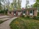 Charming single-story brick home with dark shutters, a chimney, and a walkway leading up to the front door at 6813 W Lake Anne Dr, Raleigh, NC 27612