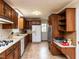 Classic kitchen with wood cabinets, tile flooring, and a gas range, offering a functional cooking space at 6813 W Lake Anne Dr, Raleigh, NC 27612
