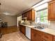 Traditional kitchen with wood cabinets, a gas cooktop, and a view into the dining area at 6813 W Lake Anne Dr, Raleigh, NC 27612