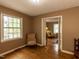 Cozy living room with hardwood floors, a large window, and a view into another room at 6813 W Lake Anne Dr, Raleigh, NC 27612