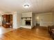 Cozy living room with a fireplace and hardwood floors, with a view into the kitchen at 6813 W Lake Anne Dr, Raleigh, NC 27612