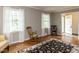 Bright living room with hardwood floors, two windows with sheer curtains, and rocking chairs to enjoy the view at 6813 W Lake Anne Dr, Raleigh, NC 27612