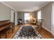 Spacious living room with hardwood floors, a piano, and plenty of seating for entertaining guests at 6813 W Lake Anne Dr, Raleigh, NC 27612