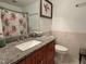 Well-lit bathroom featuring a granite countertop vanity with wood cabinets at 700 Sawmill Rd, Raleigh, NC 27615
