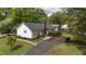 Rear exterior view featuring a brick chimney, wood deck, and driveway at 700 Sawmill Rd, Raleigh, NC 27615