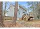 Rear exterior view of home featuring a deck and backyard with mature trees and some fencing at 7112 Benhart Dr, Raleigh, NC 27613