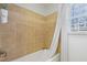 Clean, tiled bathtub with shower and white curtain is illuminated by a window at 7112 Benhart Dr, Raleigh, NC 27613