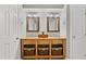 Bathroom featuring a rustic vanity with double sinks, decorative mirrors, and ample storage at 7112 Benhart Dr, Raleigh, NC 27613