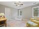Neutral bedroom with a crib, yellow floral chair, and patterned area rug at 7112 Benhart Dr, Raleigh, NC 27613