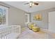 Neutral Bedroom features a white crib, chair with ottoman, natural light, and decorative painting at 7112 Benhart Dr, Raleigh, NC 27613