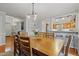 Dining room featuring hardwood floors and a view into the kitchen with breakfast bar seating at 7112 Benhart Dr, Raleigh, NC 27613