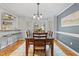 Inviting dining room with hardwood floors, large table, and access to outdoor space through french doors at 7112 Benhart Dr, Raleigh, NC 27613
