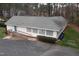 Exterior aerial view of a one-story building with ramp access, set against a backdrop of trees at 7112 Benhart Dr, Raleigh, NC 27613